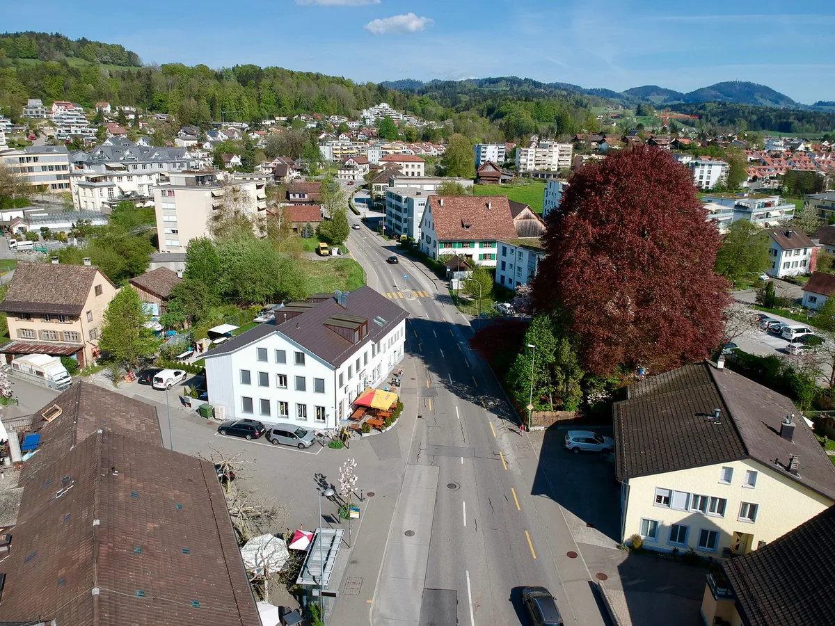 Luftaufnahme einer Strasse durch ein Wohngebiet.